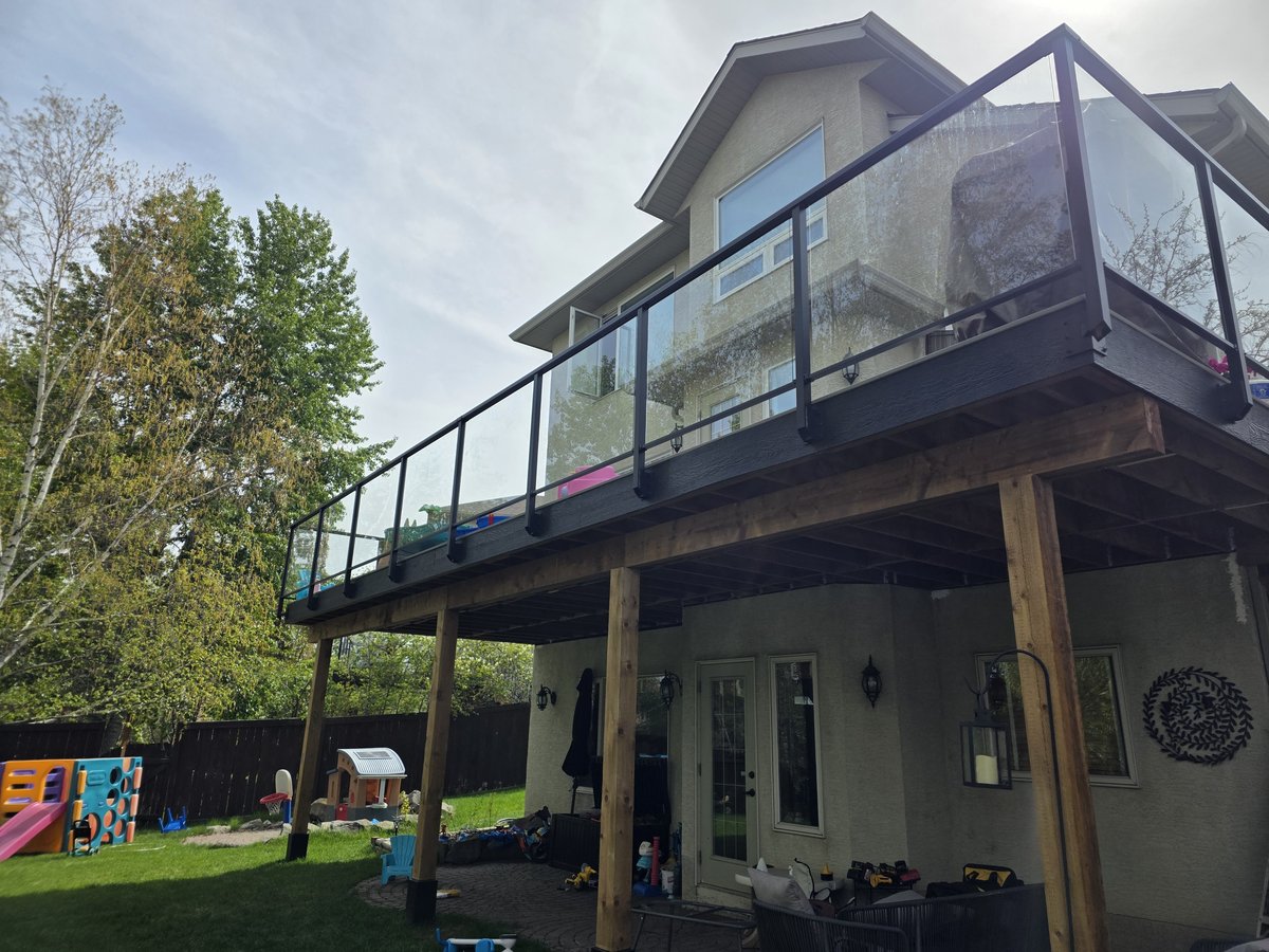 Black framed glass railing around an elevated deck