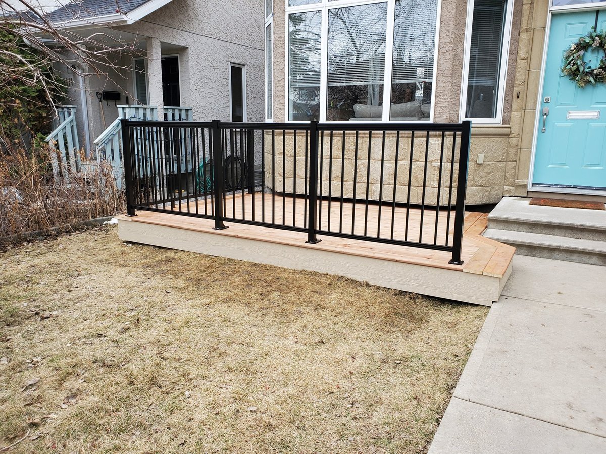 Black vertical picket railing around a low front deck