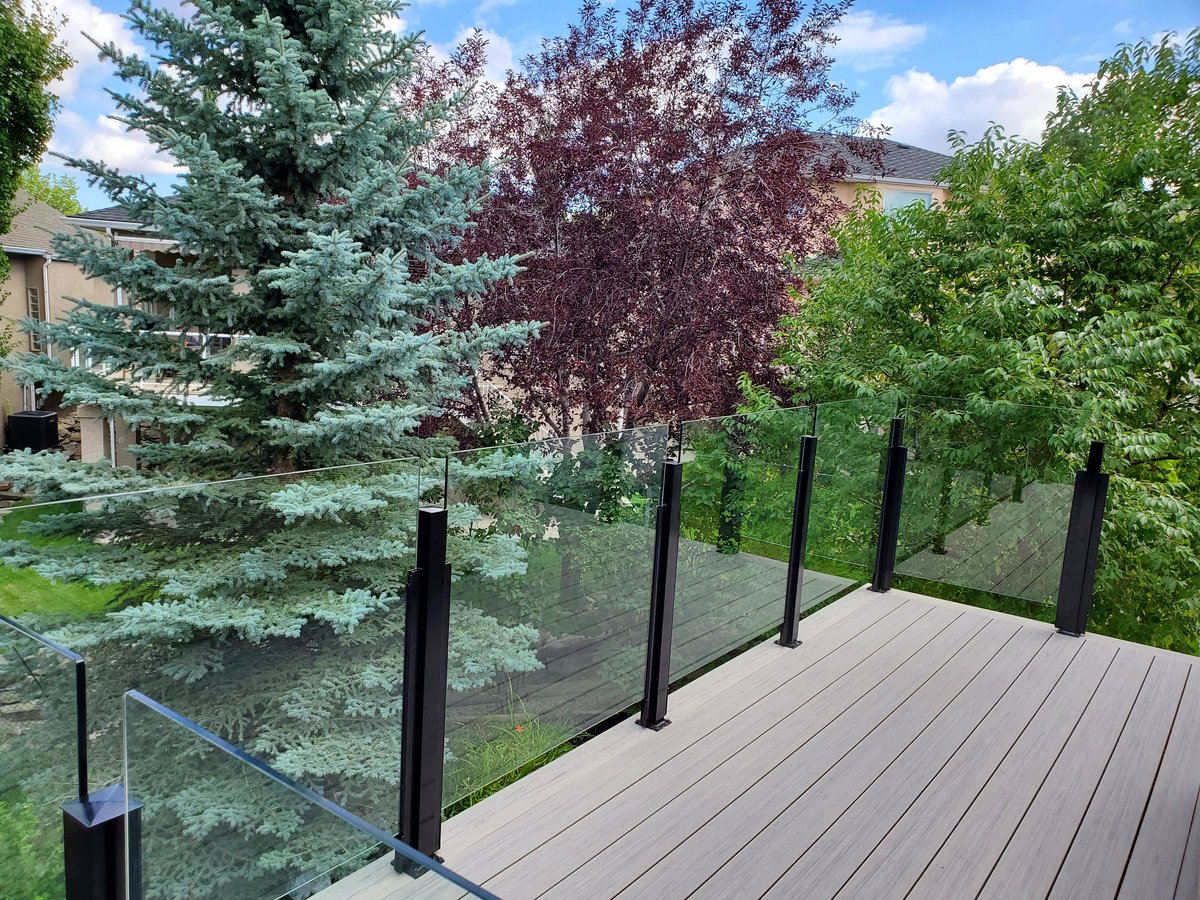 Clear glass railing between black posts without a continuous top rail